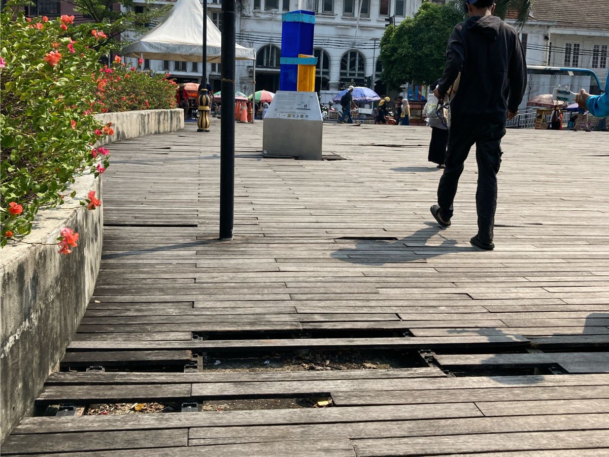 Kota Tua の木の橋。板が外れたりずれたりして、すき間から下が見えている
